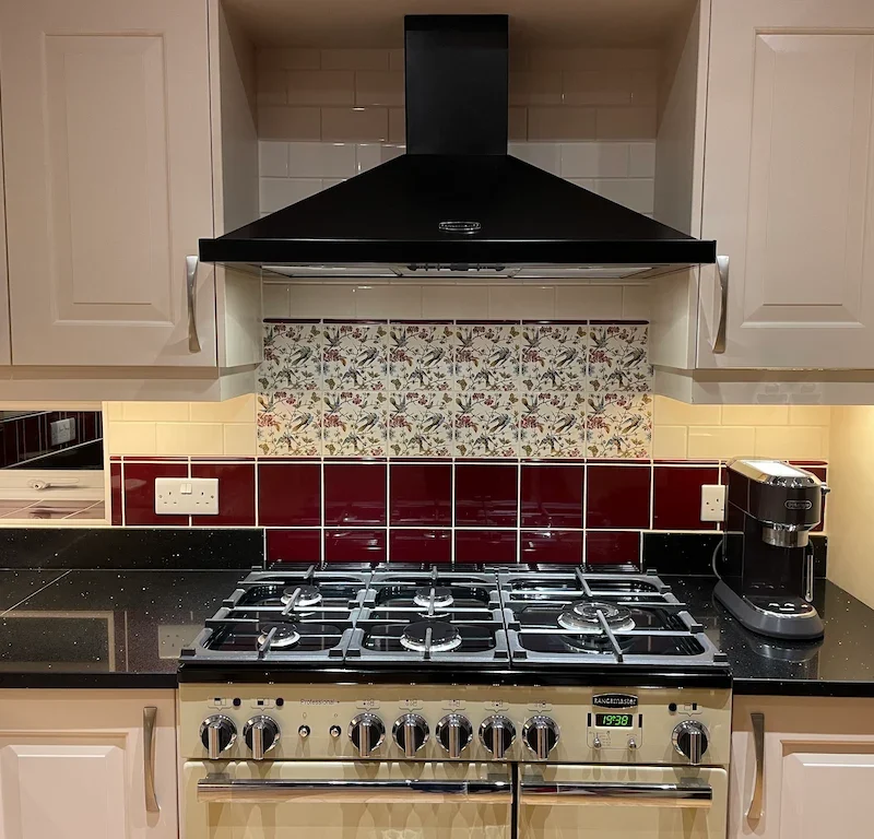 Bluebird patterned wall tile shown in a kitchen splashback paired with burgundy and cream tiles