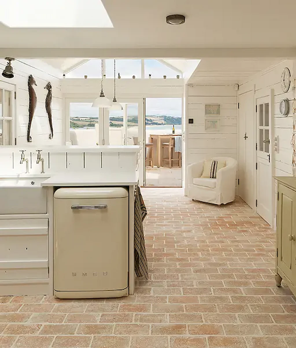 Rustic terracotta brick floor tiles in a coastal-inspired kitchen, creating a relaxed and timeless look with natural earthy colours.