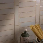 Stone Glaze Ceramic Mink Tile 5x20cm in gloss finish, laid in horizontal brick bond, styled with pasta and olive oil bottle