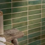 Stone Glaze Ceramic Olive Leaf Tile 5x20cm in gloss finish, laid in horizontal brick bond, styled with rustic stool and jar
