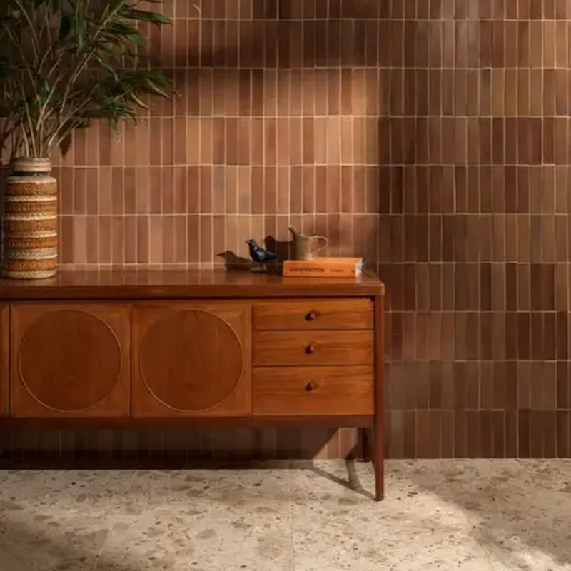 Stone Glaze Ceramic Tan 5x20cm wall tiles in a vertical brick layout, styled with mid-century furniture and terrazzo flooring