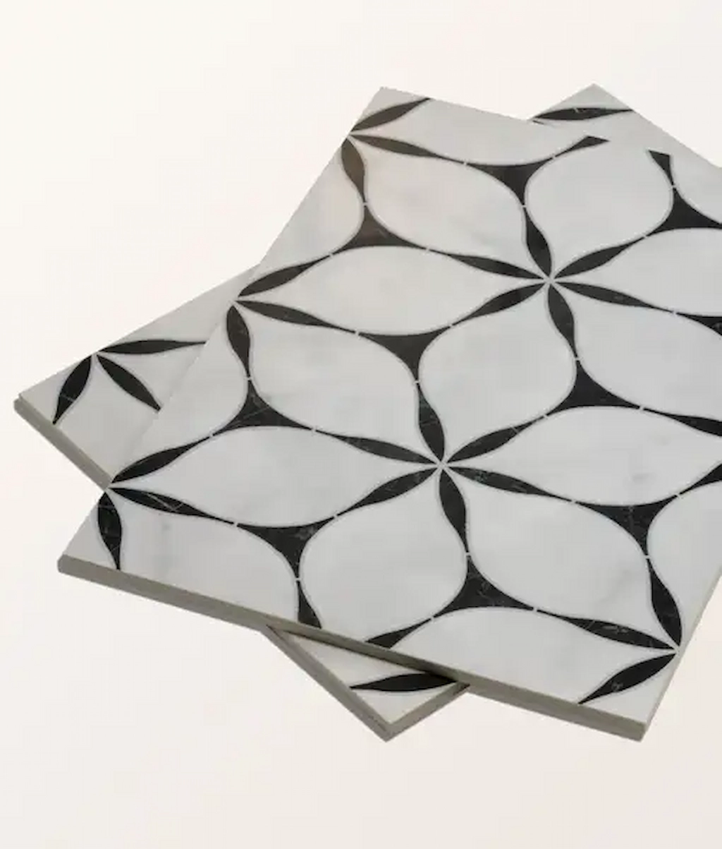 Byzantine Elysium porcelain tile in a black and white geometric petal pattern, shown in an angled stack