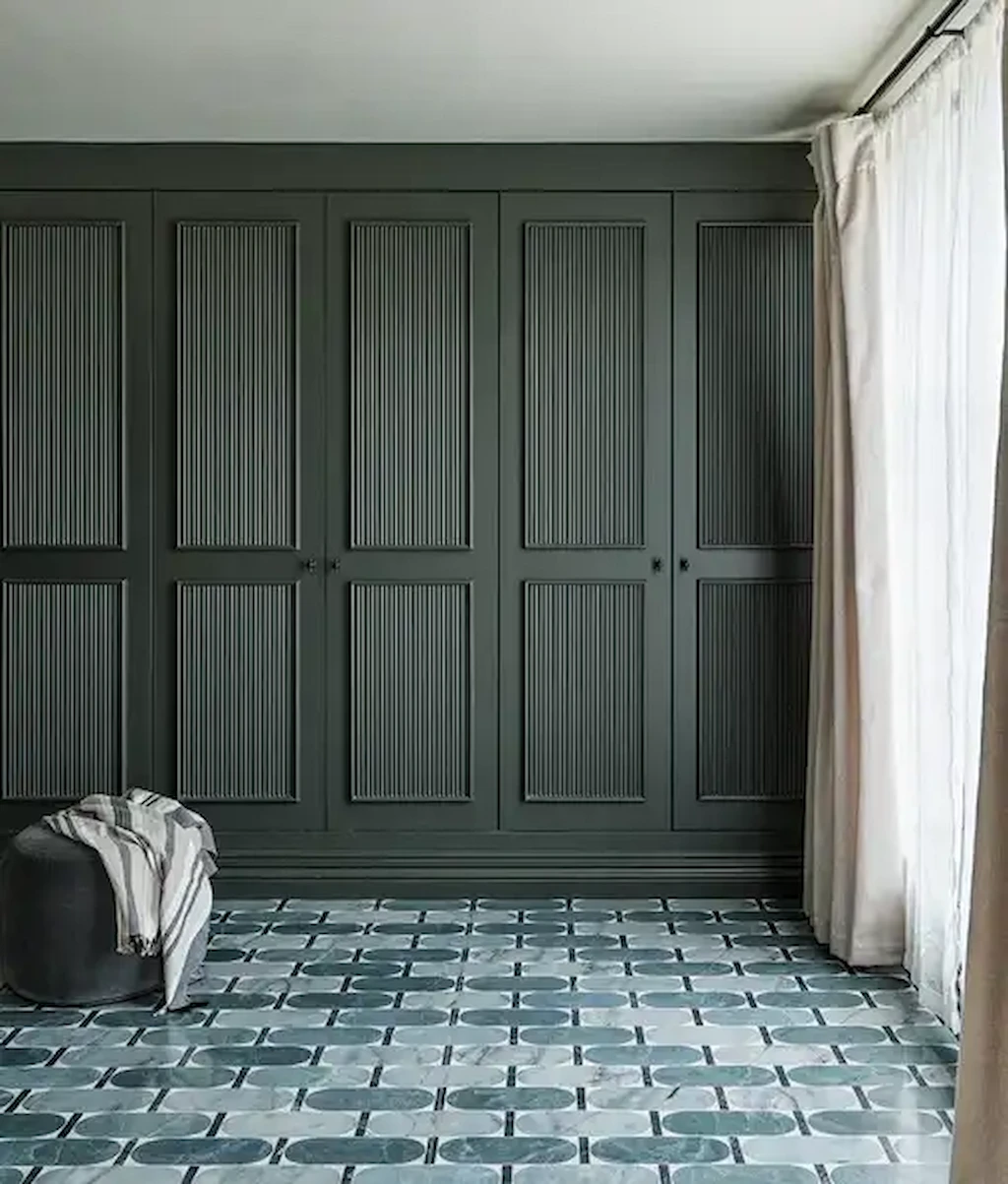 Bedroom with Byzantine Lauro porcelain floor tiles in blue-grey oval pattern, paired with dark fitted wardrobes