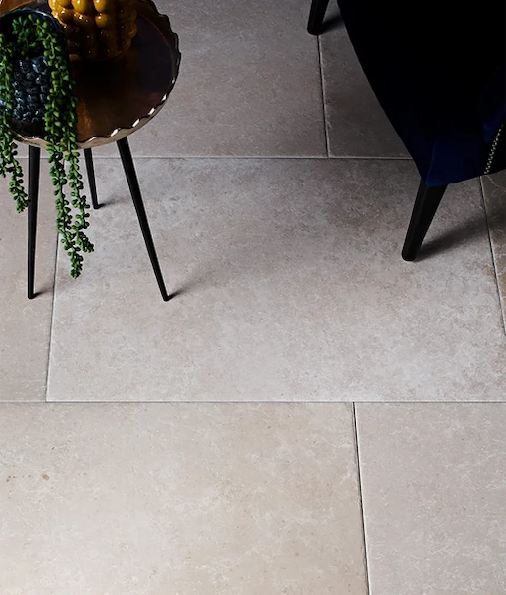 Limestone-effect porcelain floor tiles in a neutral open-plan kitchen