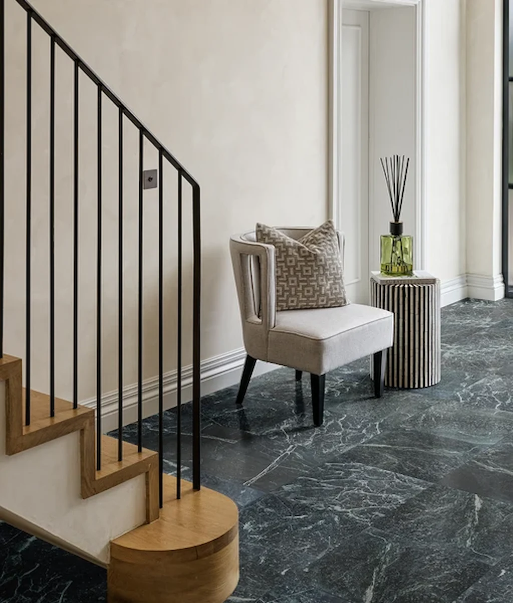 Versailles Marble Vert Honed 45.7x45.7cm tiles in a hallway, showing deep green tones with soft white veining beneath a modern staircase.