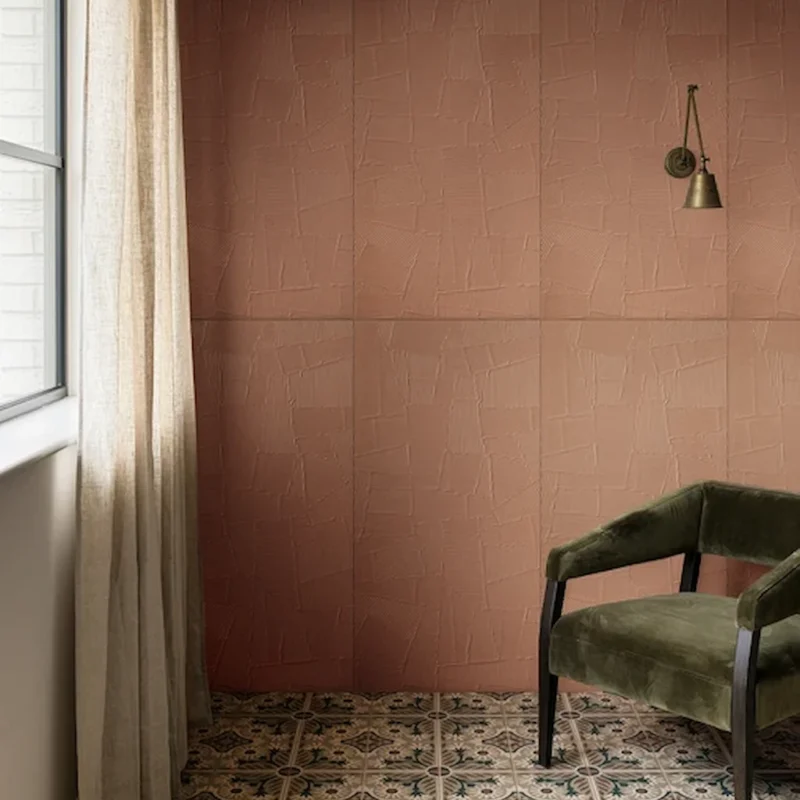 Indirah Porcelain Mocha porcelain tiles laid in a repeating geometric pattern, shown in a warm interior with natural light, neutral walls and vintage-style furniture.