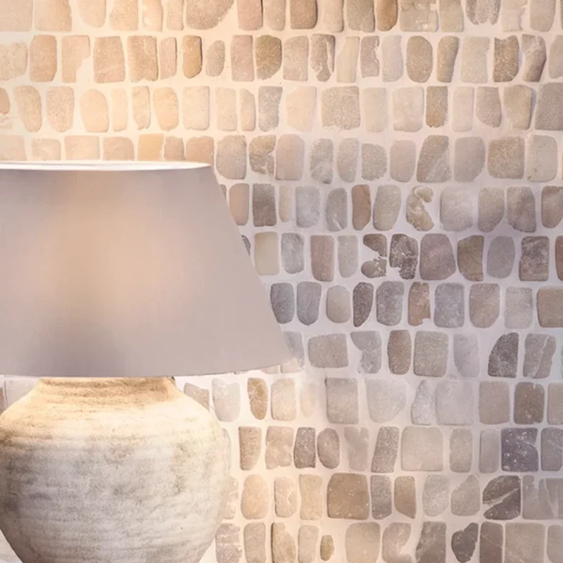 Enso Cobble Mosaic Strip Sand tile close-up wall detail with soft beige and grey stone variation, rounded cobble shapes, natural finish