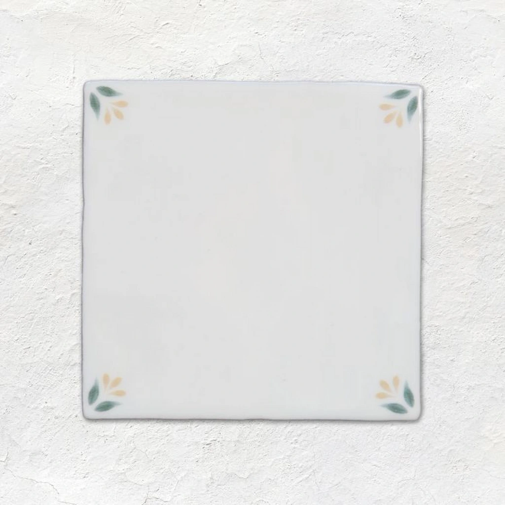 Spring April Primrose Delft style tile 13x13cm with yellow and green leaf corner detail on gloss off-white ceramic