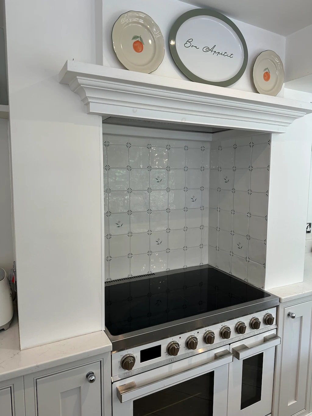 Handmade-style Spring May and Lucie kitchen tiles with floral detailing, installed as a cooker splashback in a classic country kitchen
